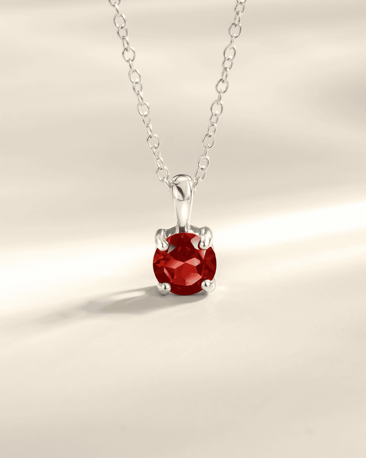 Sterling silver solitaire pendant necklace with red faceted round gemstone