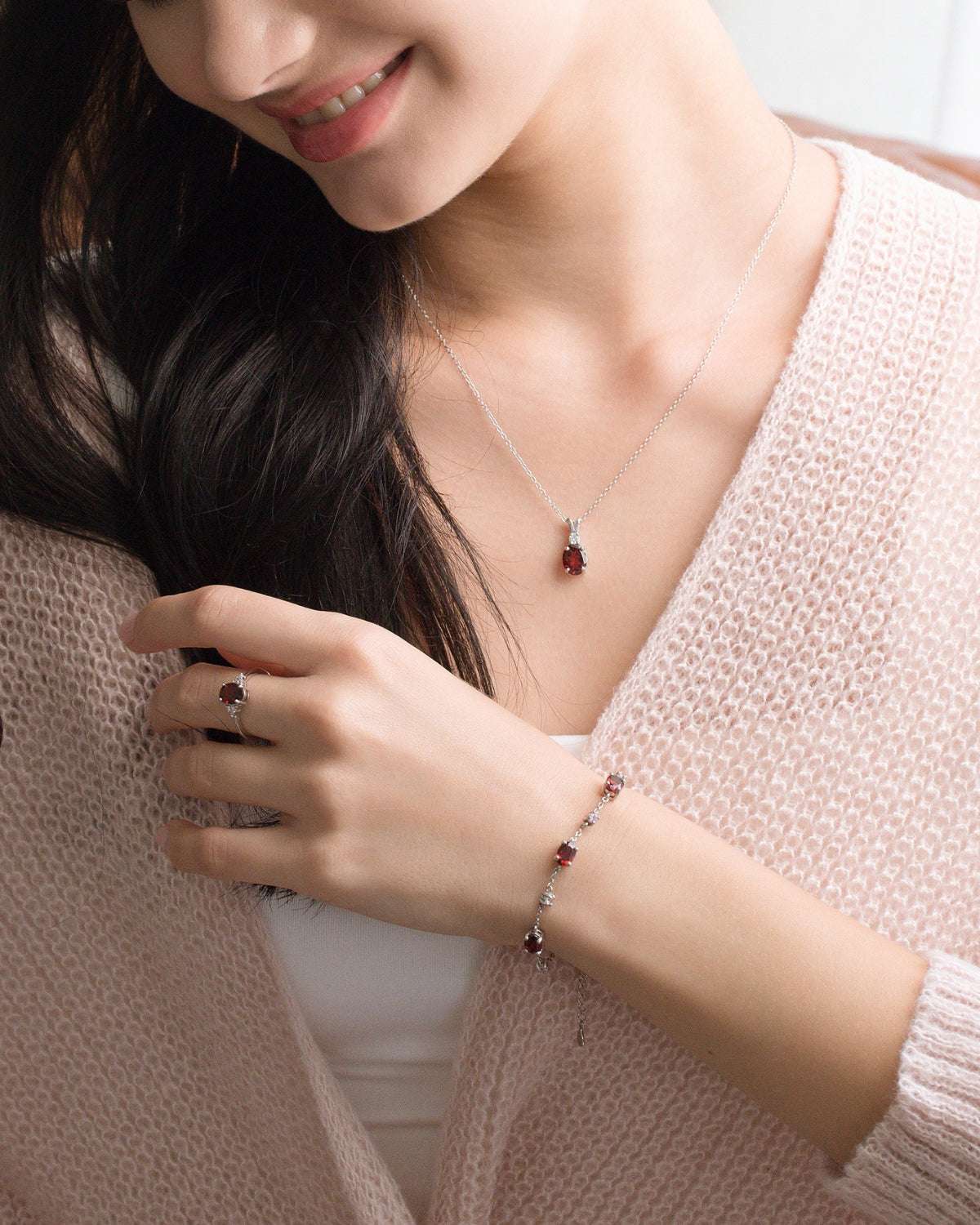 Sterling silver red gemstone necklace and bracelet worn with small stud earrings