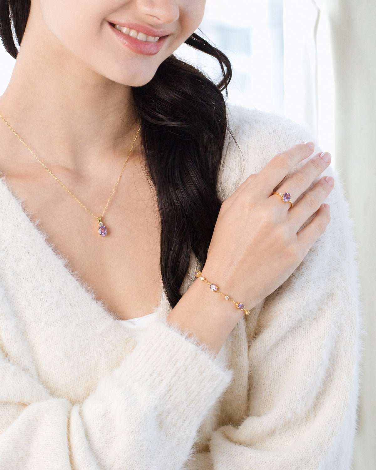 Gold vermeil necklace and bracelet with purple gemstone details on model wrist and neck.
