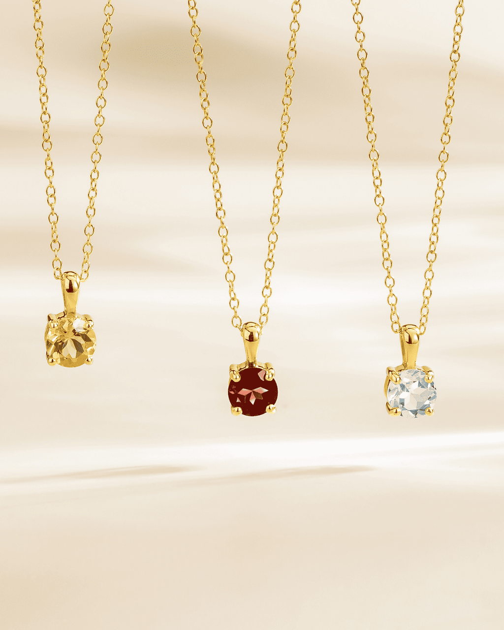 Gold vermeil chain with light blue solitaire gemstone pendant and round red pendant