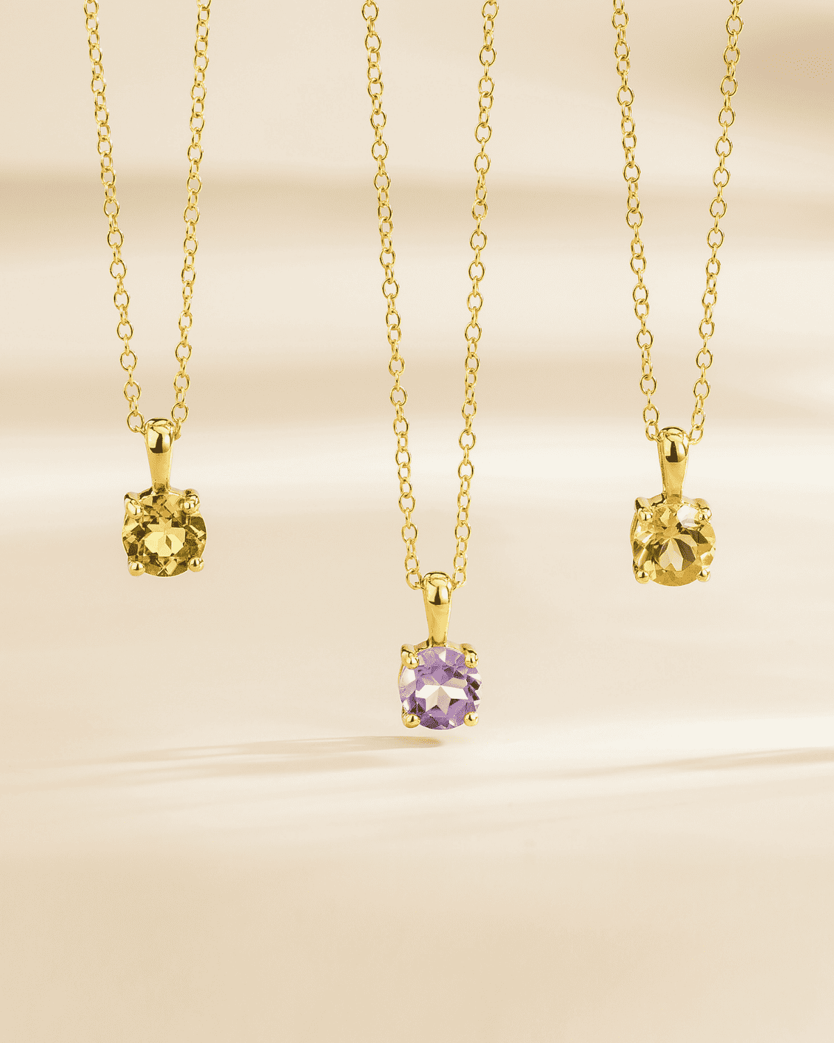 Gold vermeil pendant necklace lineup with assorted gemstone charms, including lavender