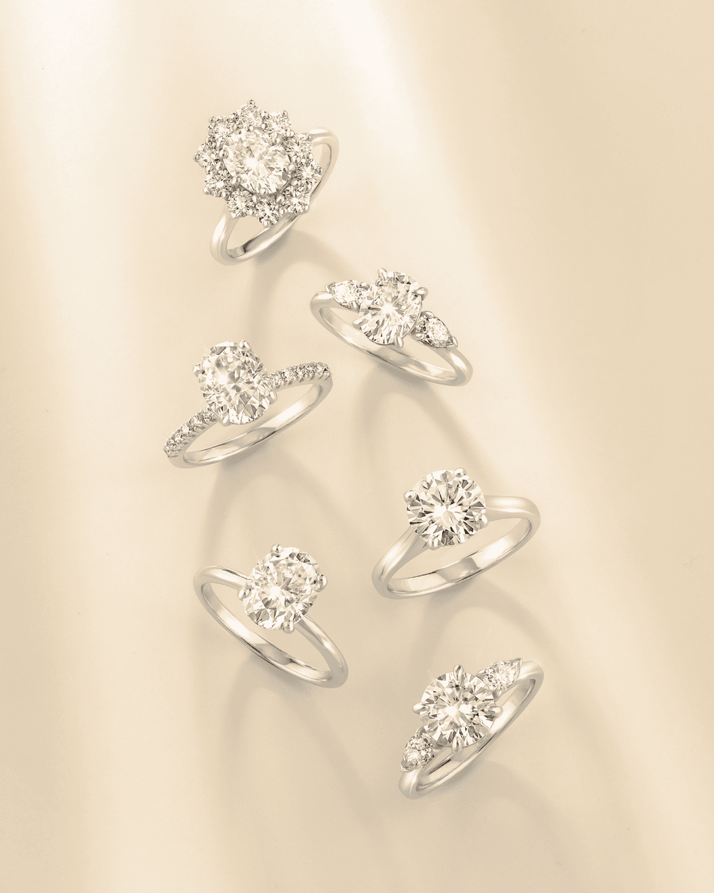 Multiple oval three-stone sterling silver rings with clear stones, front views