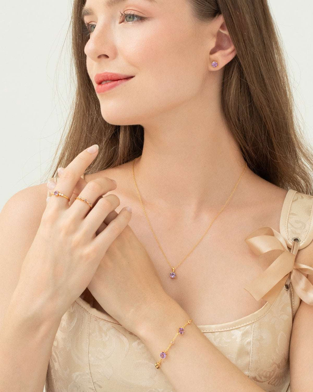 Gold vermeil five-stone ring with lavender center stone and small clear stones on hand