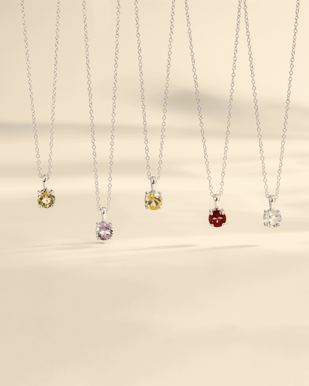 Set of silver chain solitaire pendants with yellow, purple, red, and clear stones