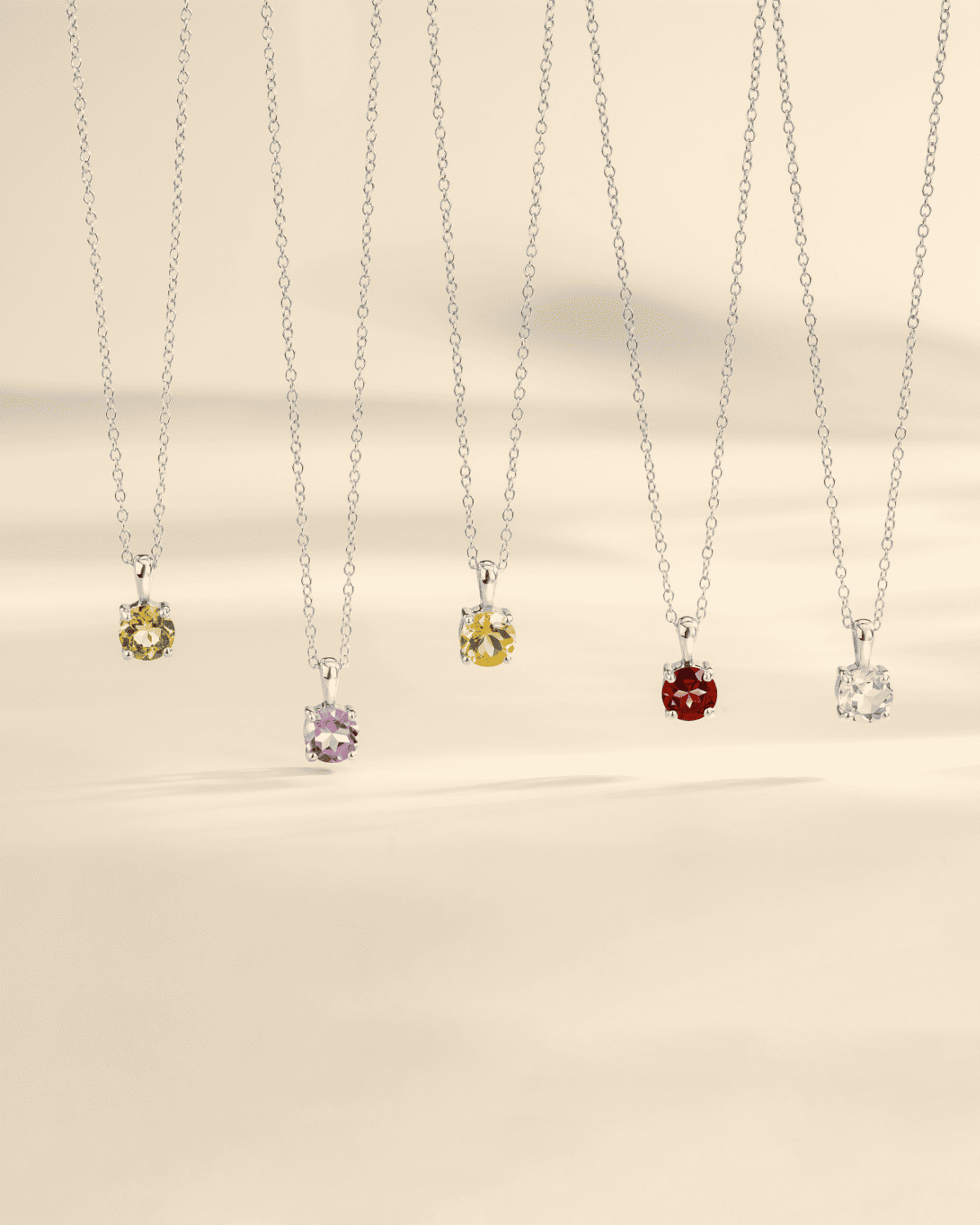 Set of silver chain solitaire pendants with yellow, purple, red, and clear stones