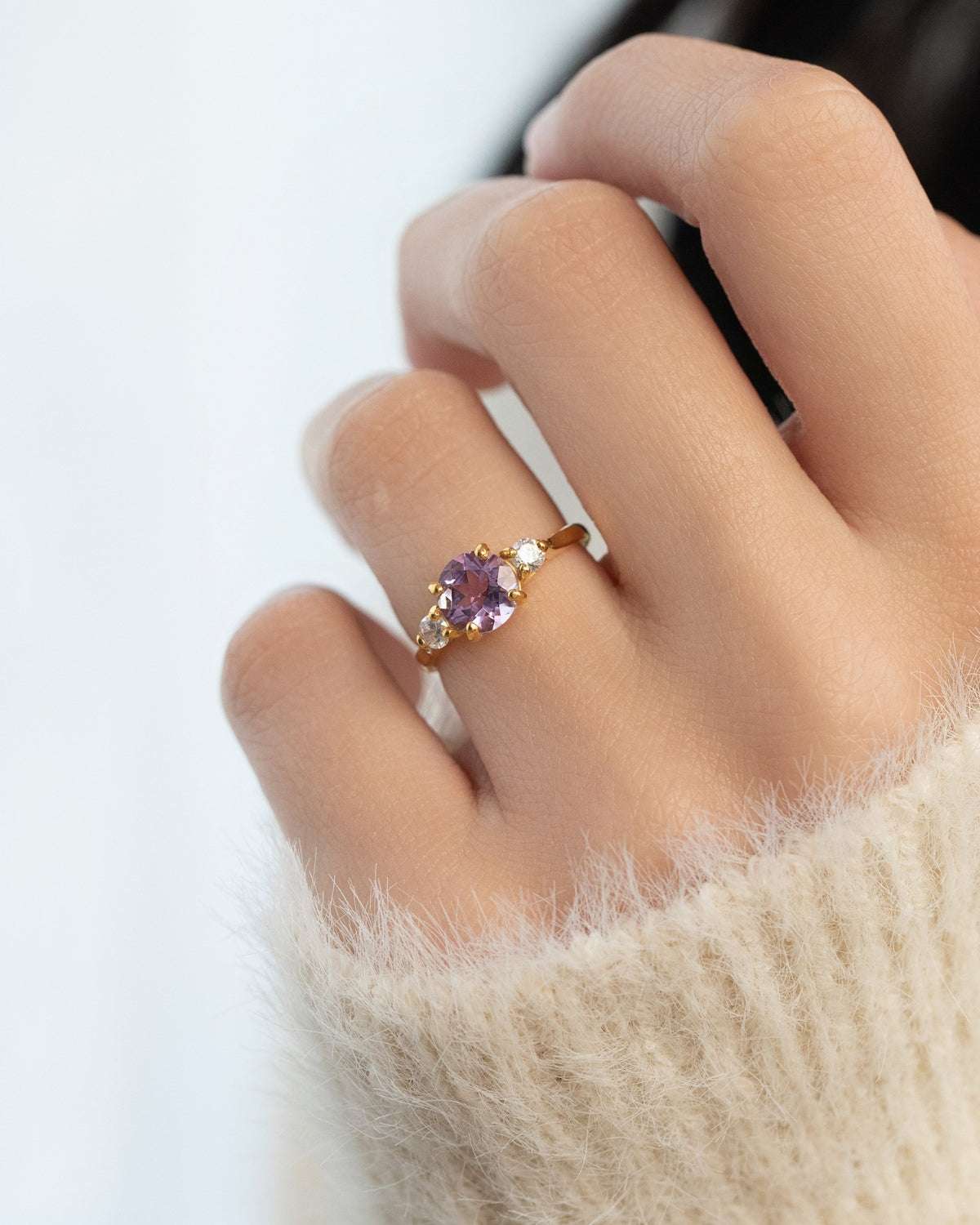 Lavender amethyst three-stone ring with gold-tone setting on hand