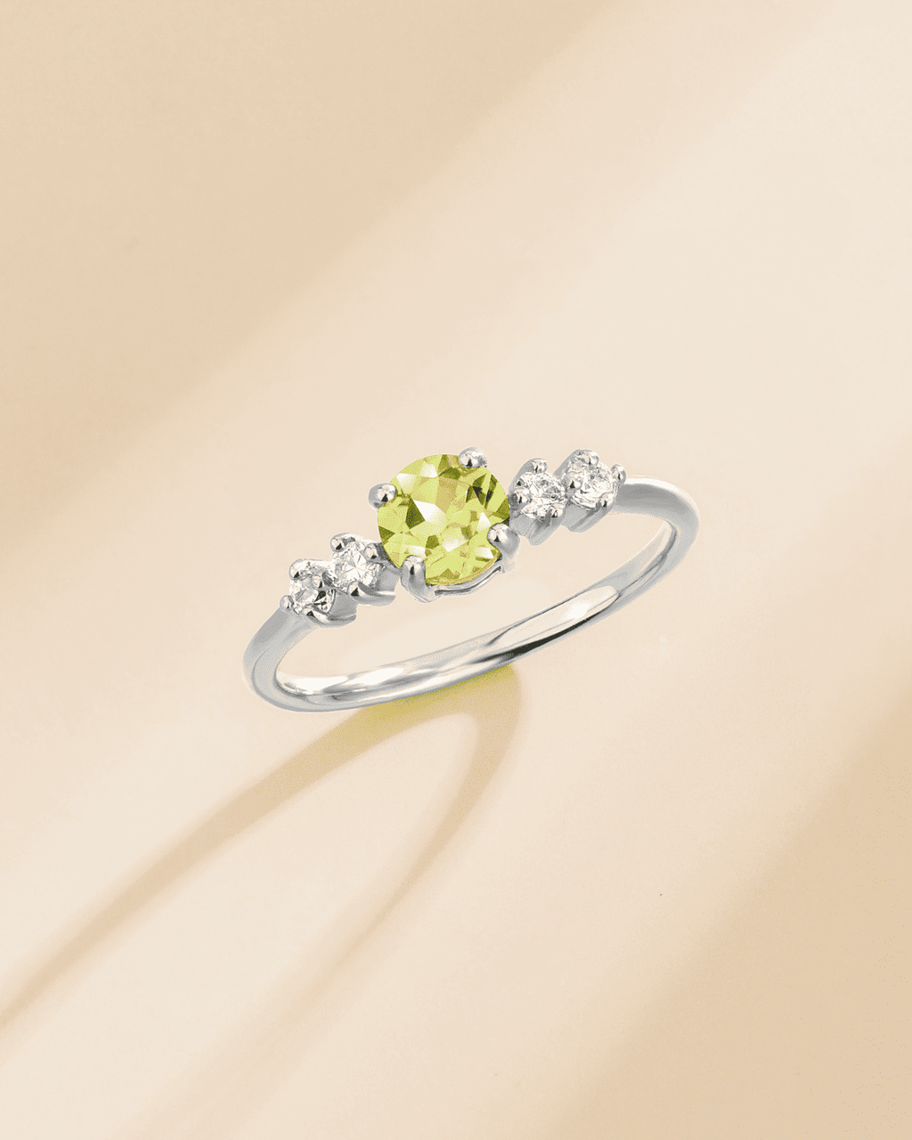 Silver five-stone ring with lime-green round center and four small clear stones