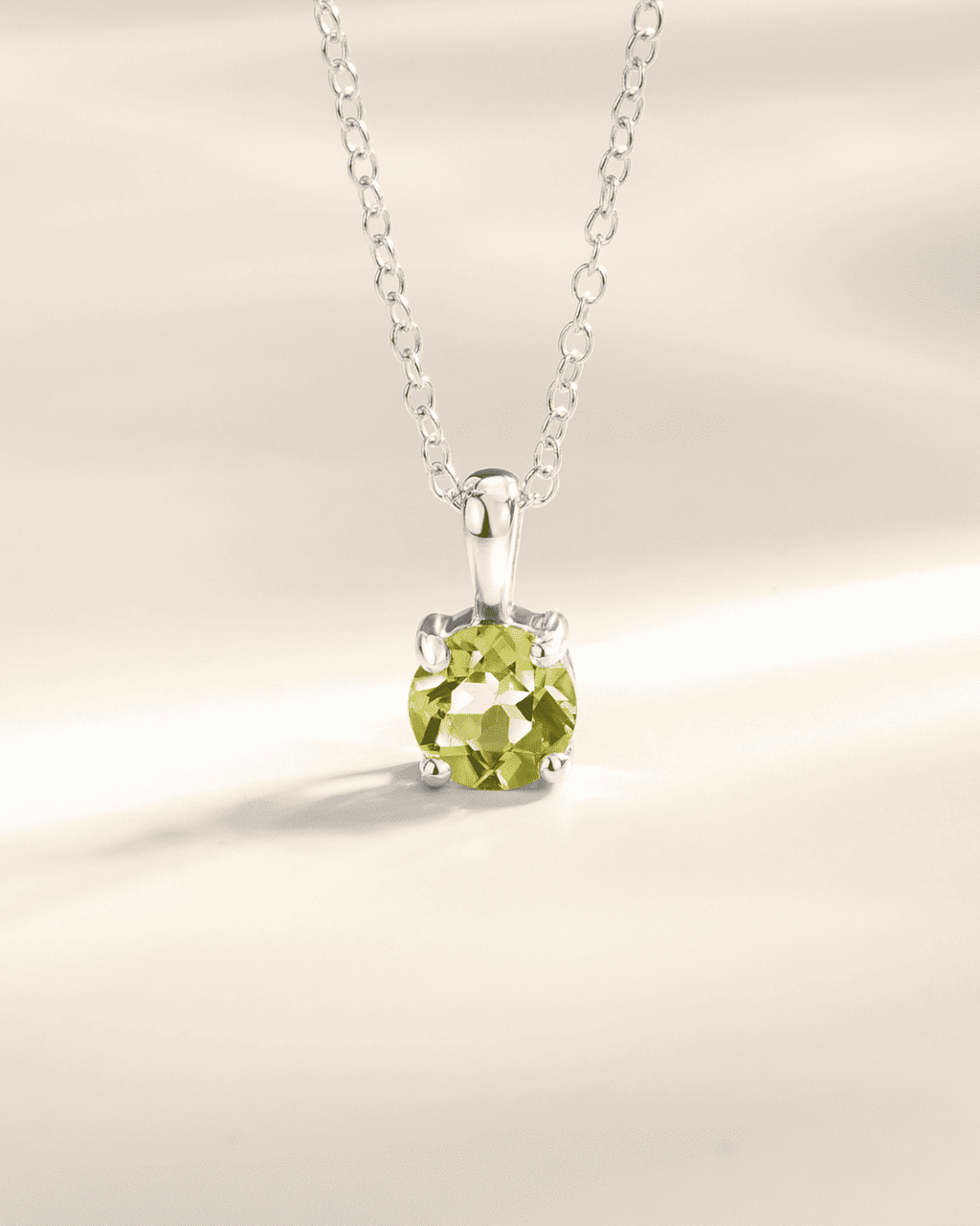 Sterling silver solitaire pendant necklace with round peridot-green gemstone