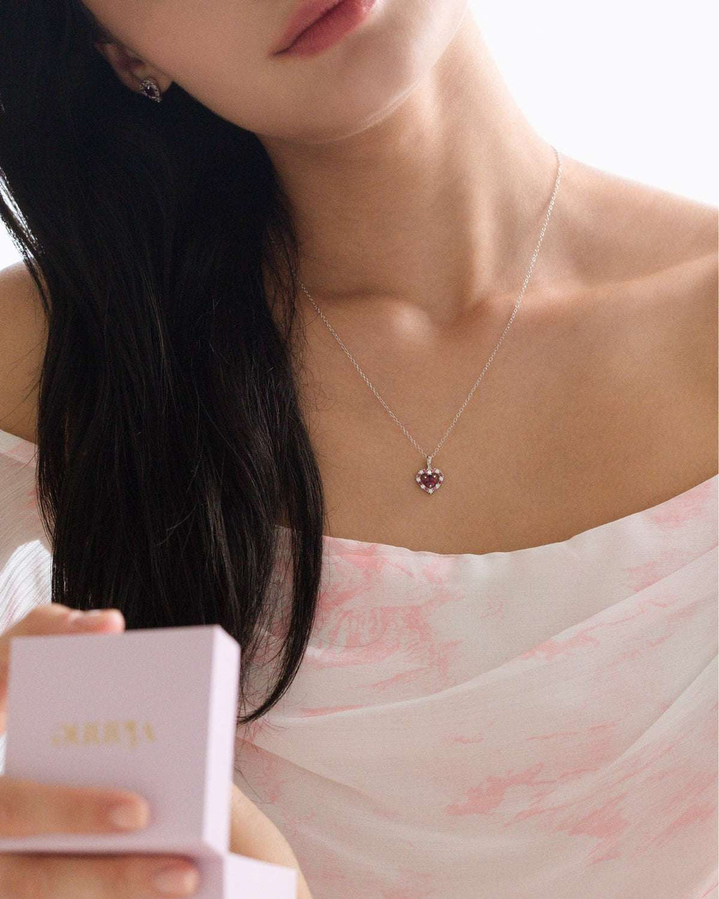 Sterling silver heart pendant necklace worn with fine chain at neckline