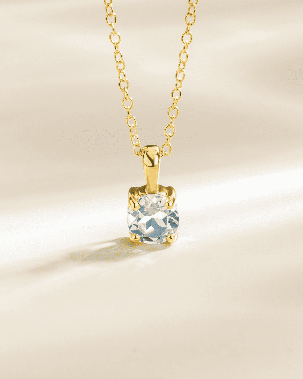 Gold vermeil solitaire pendant necklace with light blue gemstone in square setting