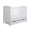 White mini cot bed with vertical bars and under-drawer panel, front-left view