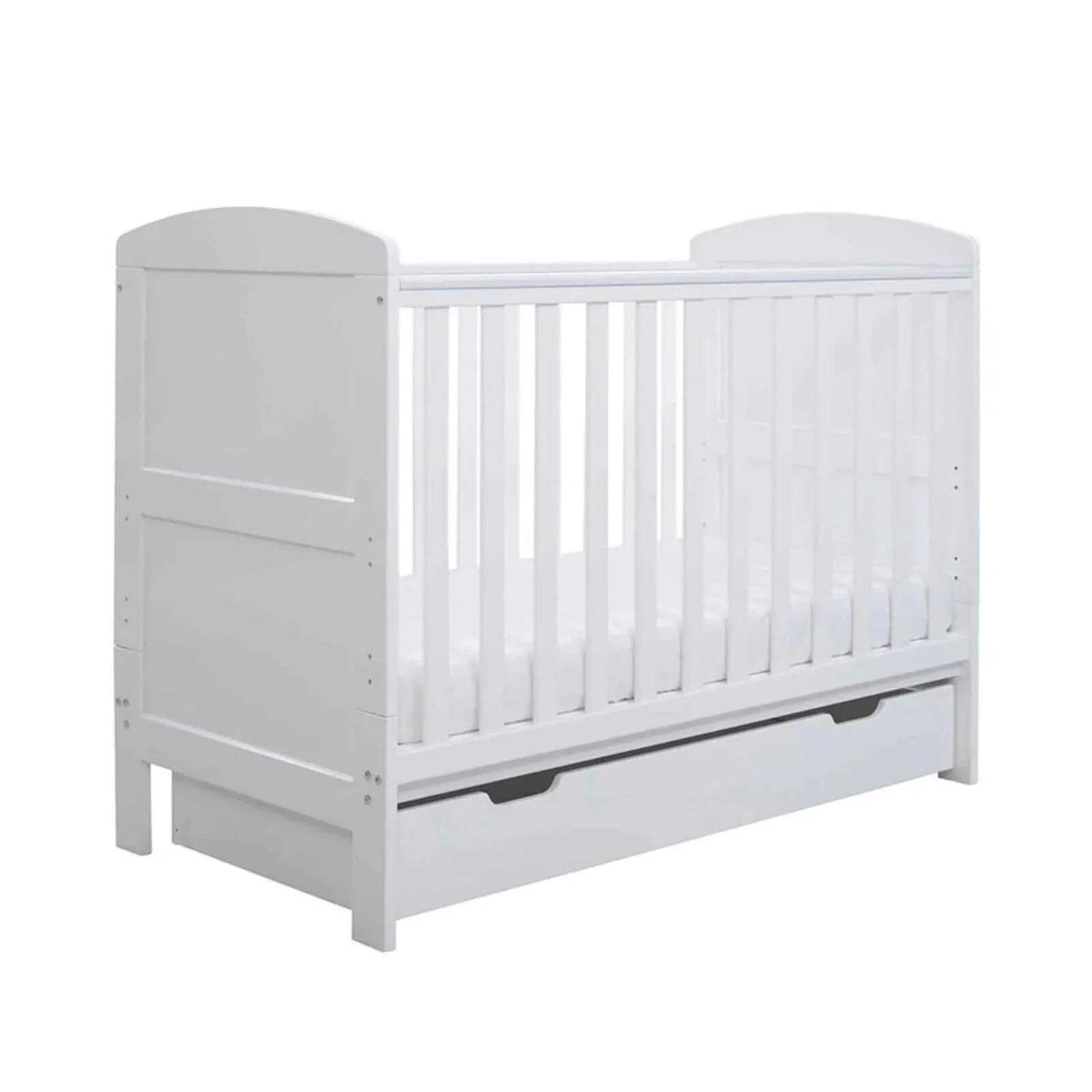 White mini cot bed with vertical bars and under-drawer panel, front-left view