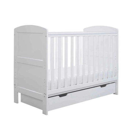 White mini cot bed with vertical bars and under-drawer panel, front-left view