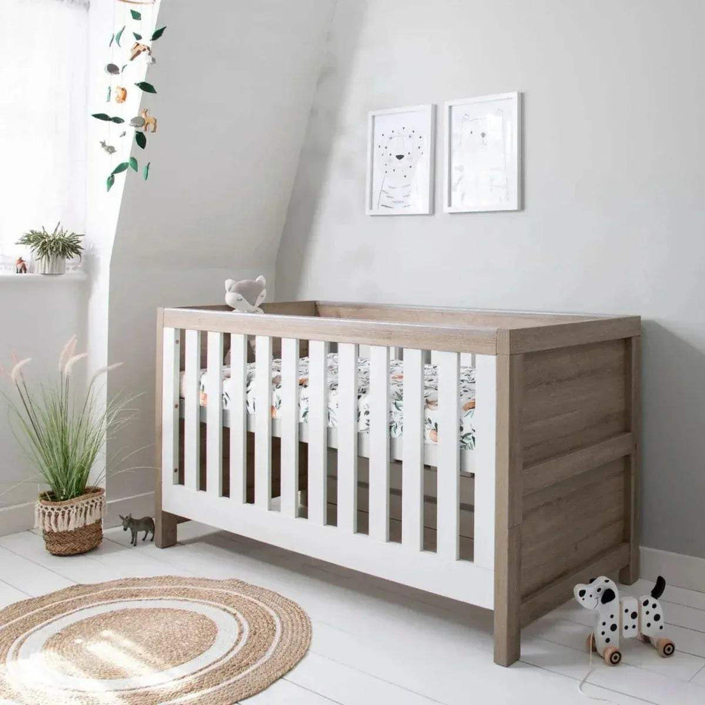 3-in-1 cot bed with white slatted rails and light oak end panels, with mattress