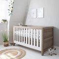 3-in-1 cot bed with white slatted rails and light oak end panels, with mattress