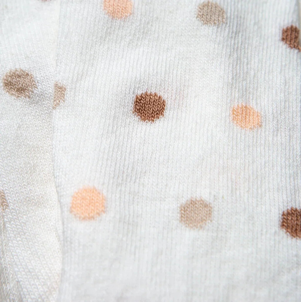 Girls polka dot tights close-up of scattered beige, peach, and brown dots