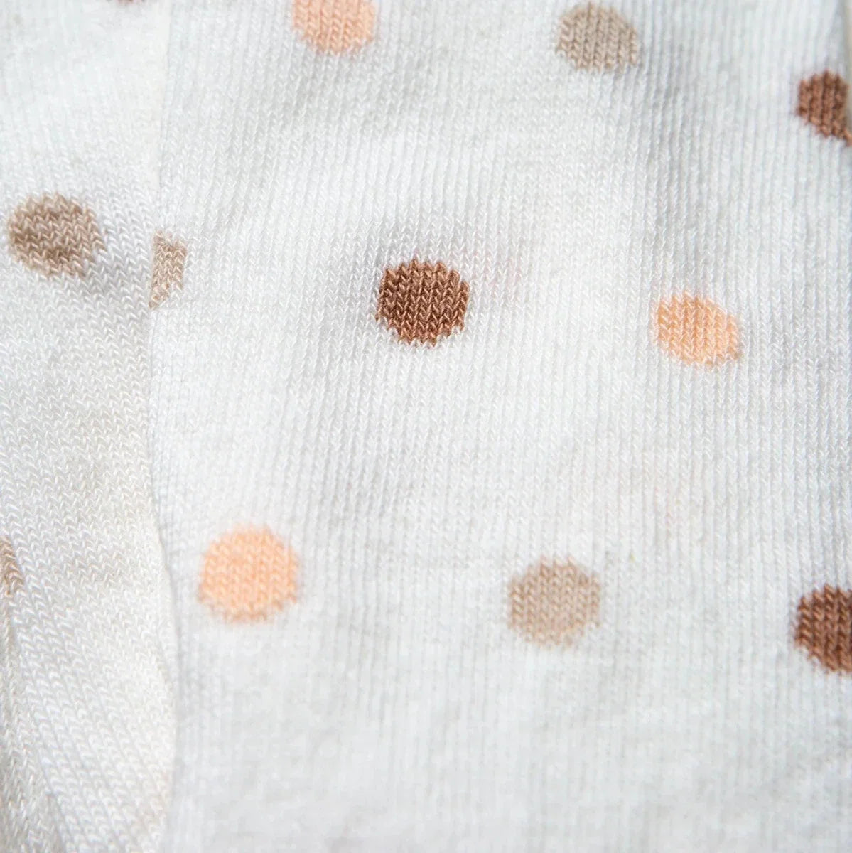 Girls polka dot tights close-up of scattered beige, peach, and brown dots