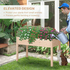 Wooden raised planter with blooming flowers while watering with a metal watering can