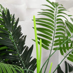 Artificial palm plant with green fronds and tall central leaf stem, close-up