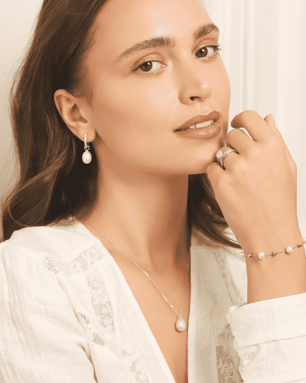 Model wearing sterling silver hoop earrings with removable freshwater pearl drops