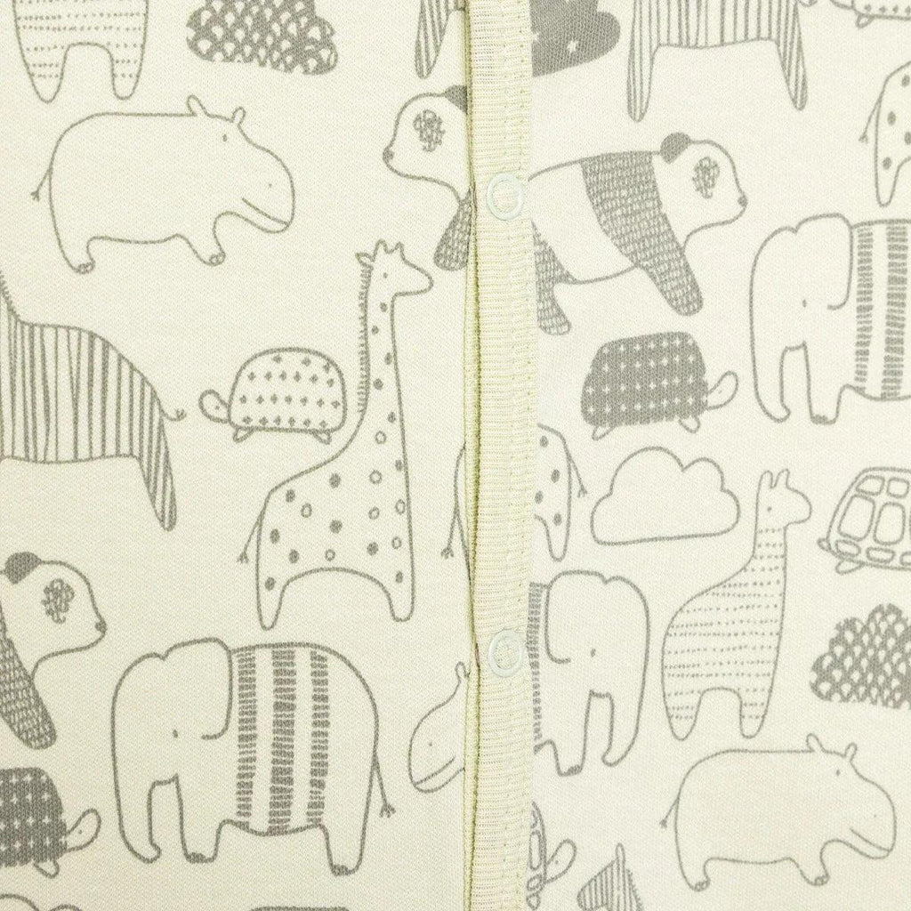 Close-up of animal-print fabric with elephants and jungle scenes on the jumpsuit