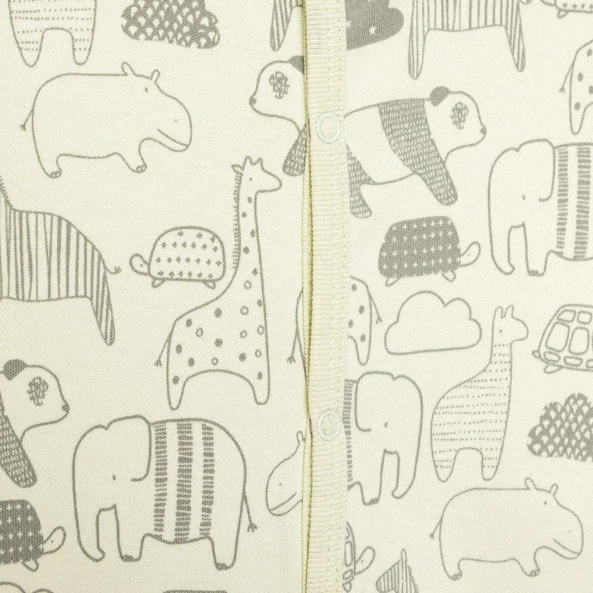 Close-up of animal-print fabric with elephants and jungle scenes on the jumpsuit