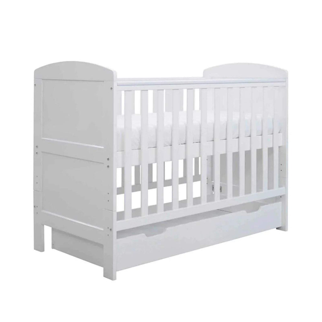 White mini cot bed with vertical rails and under-drawer panel, front-right view