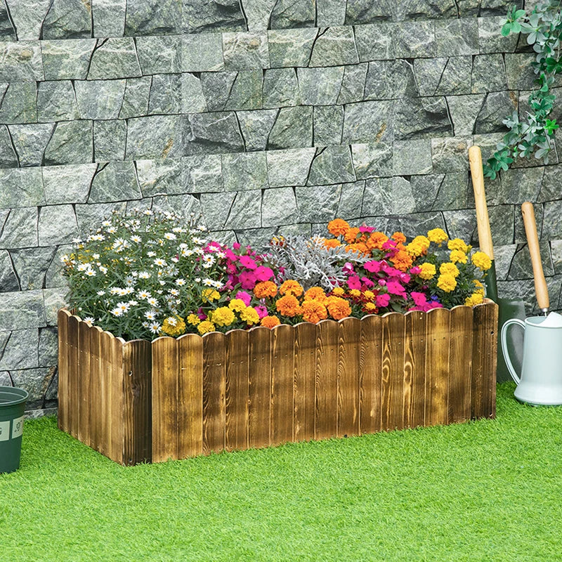 Wooden raised garden bed planter box filled with colorful flowers outdoors