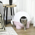 Pink and white enclosed cat litter box with front door and cat standing outside