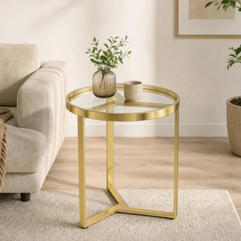 Gold round side table with clear glass top and geometric metal frame for small spaces