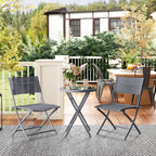 Grey round glass-top bistro table with two folding chairs on outdoor patio