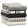 Stack of terry kitchen towels in grey tones with stripes, check and textured solid panels