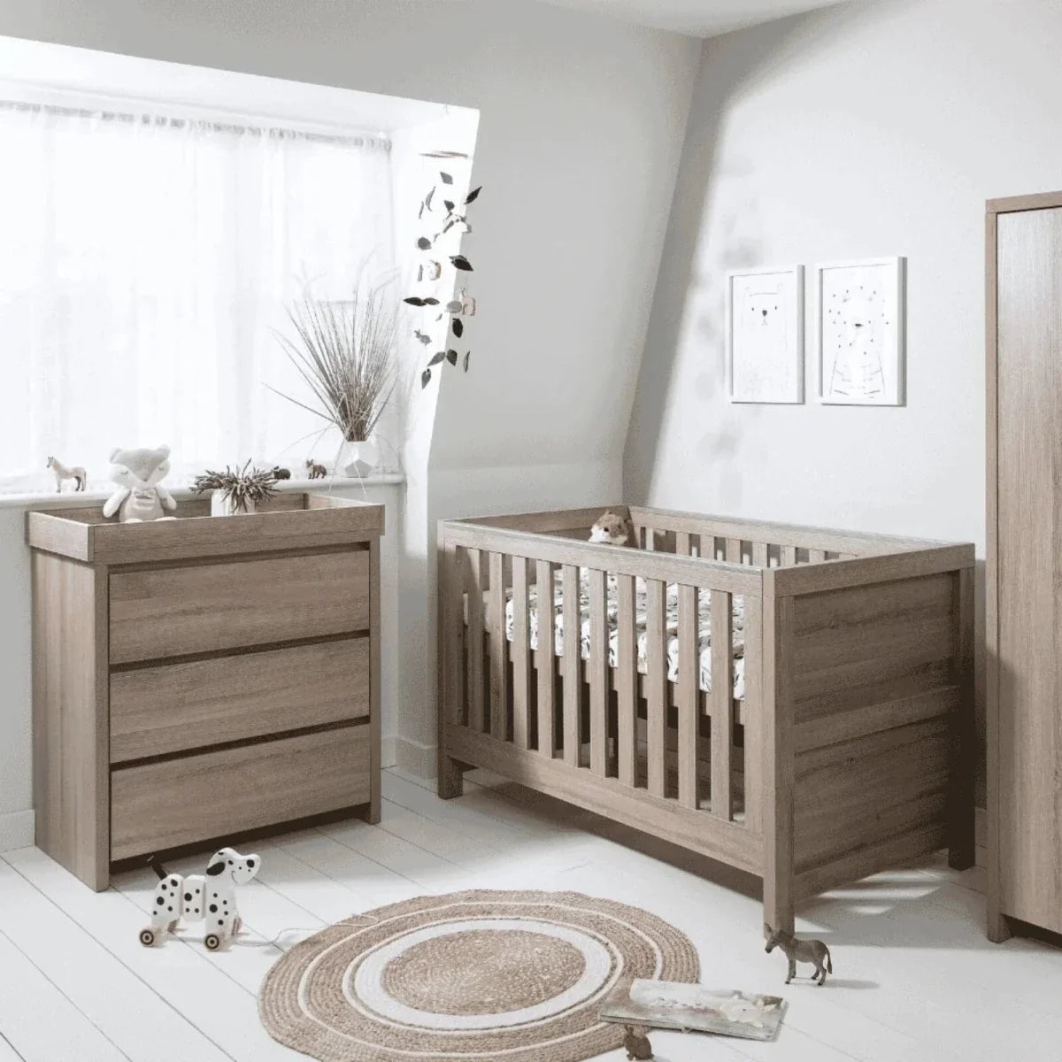 Oak changing unit in nursery corner with three-drawer cabinet and side rail.