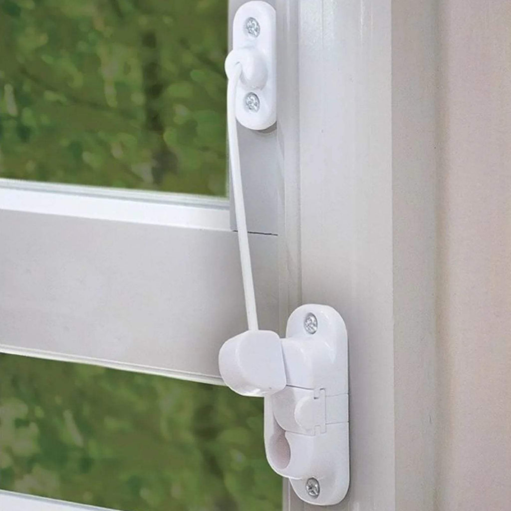 White window restrictor arm with cable, mounted on window frame