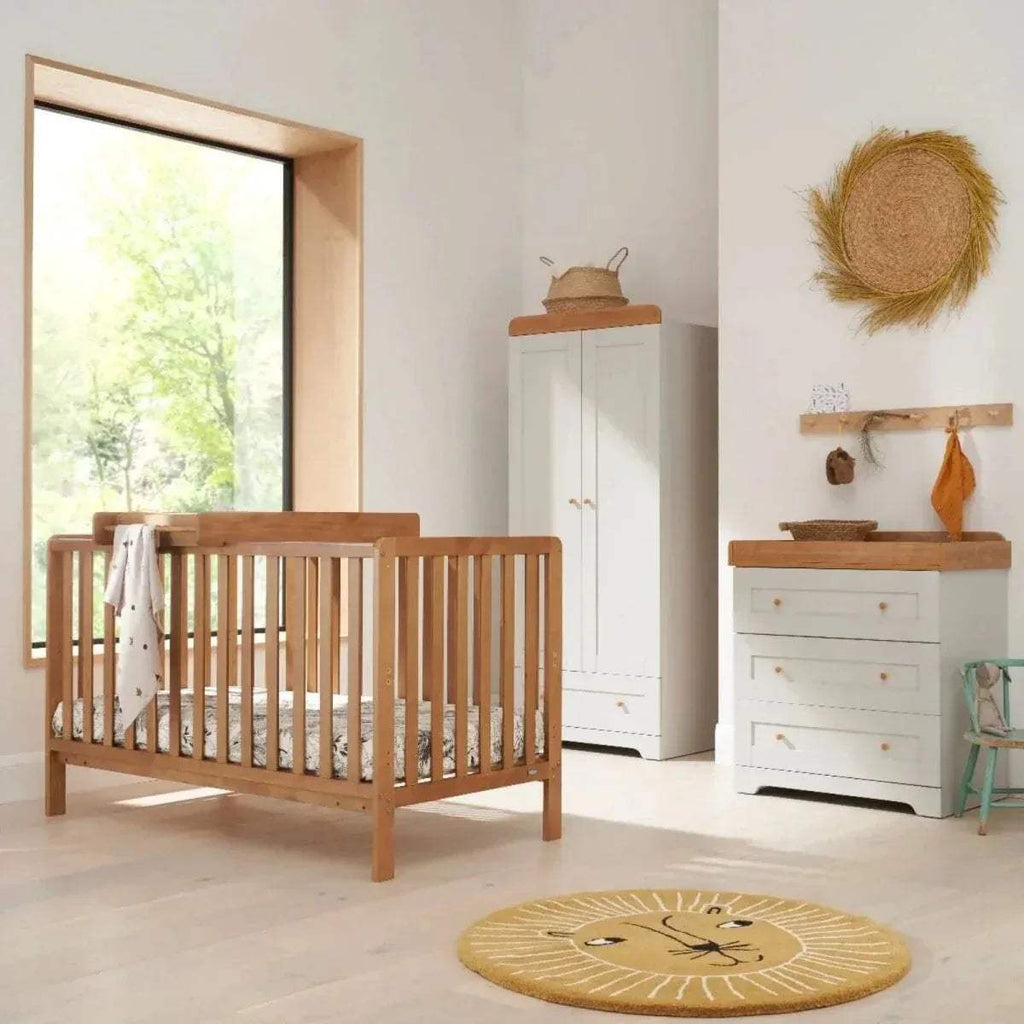 Honey oak wooden cot bed with open slats and matching white storage cabinet set