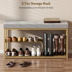 Grey tufted shoe bench with gold steel frame holding shoes on two-tier shelves