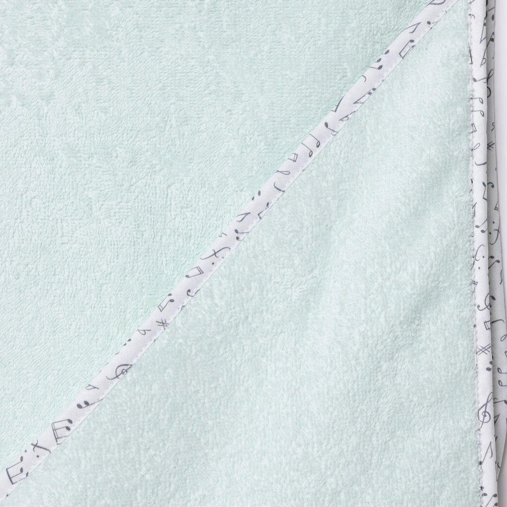 Baby bath towel corner close-up, light blue with purple stitching and patterned edge