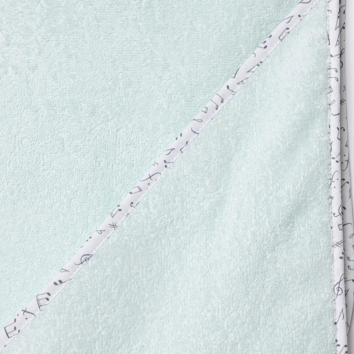 Baby bath towel corner close-up, light blue with purple stitching and patterned edge