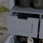 Grey bathroom storage drawer with recessed panel handle, partially opened above storage compartment.
