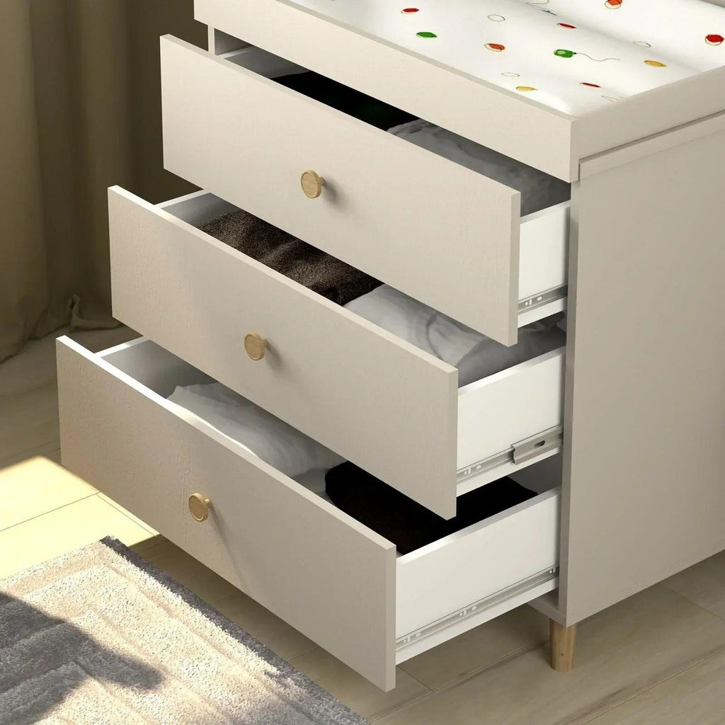 Kids changing dresser with drawers open, showing dark interior shelves and brass knob pulls