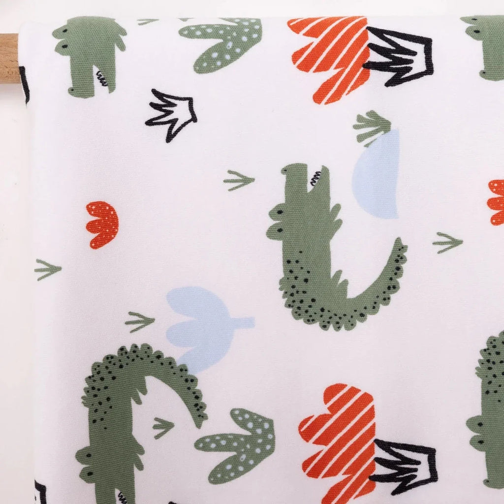 Close-up of white kids blanket fabric with green cactus and red hearts