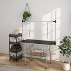 Adjustable pet grooming table with black rubber top and wire storage basket