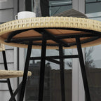 Underside view of woven rattan tabletop edge with black support frame