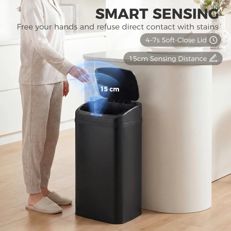 Black sensor trash bin with open lid and hand-free lid lift shown in use.