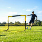 Yellow pop-up football goal with white netting, wide outdoor grass view