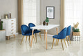 White dining table with four blue upholstered chairs and wooden legs