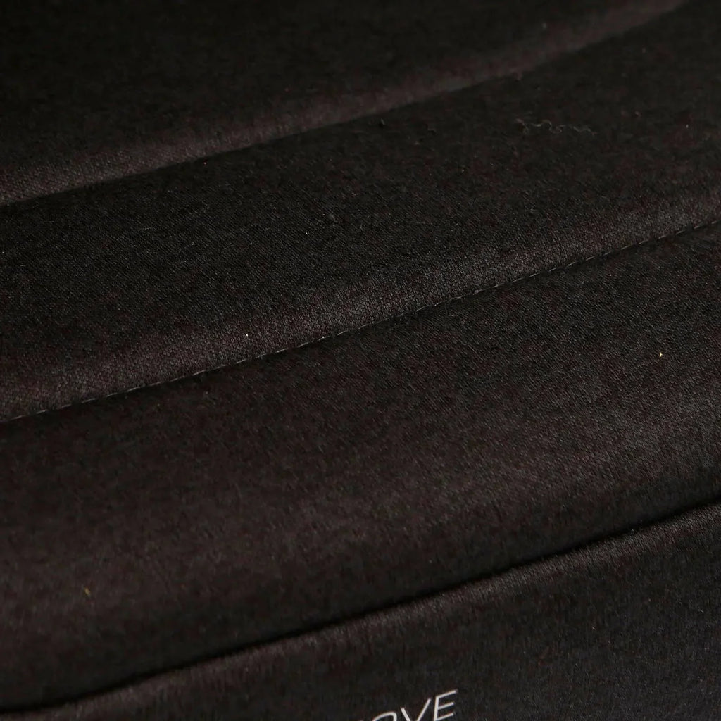 Black fabric upholstery close-up with stitched seam and dark finish
