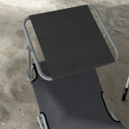 Grey folding sun lounger with dark fabric seat, backrest, and metal frame details