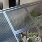 White aluminium frame greenhouse close-up of clear polycarbonate panel edges and frame