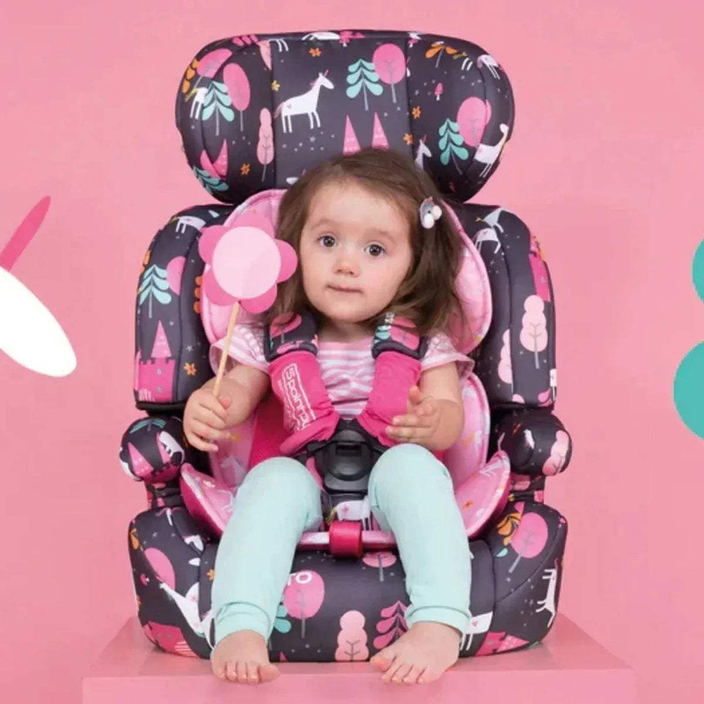 Charcoal car seat with pink heart print, child seated with harness fastened